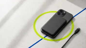 Magnetisk powerbank festet til en mobil over en markert grønn ladering