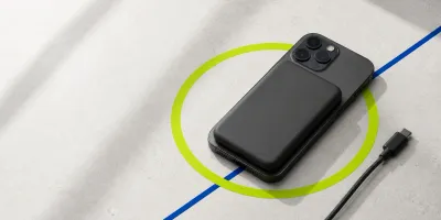 Magnetisk powerbank festet til en mobil over en markert grønn ladering