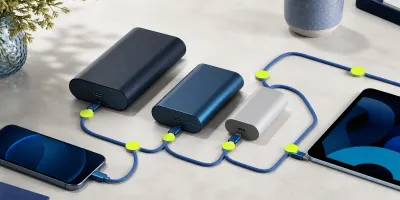 Tre powerbanker koblet til mobil og nettbrett med blå USB-C-kabler